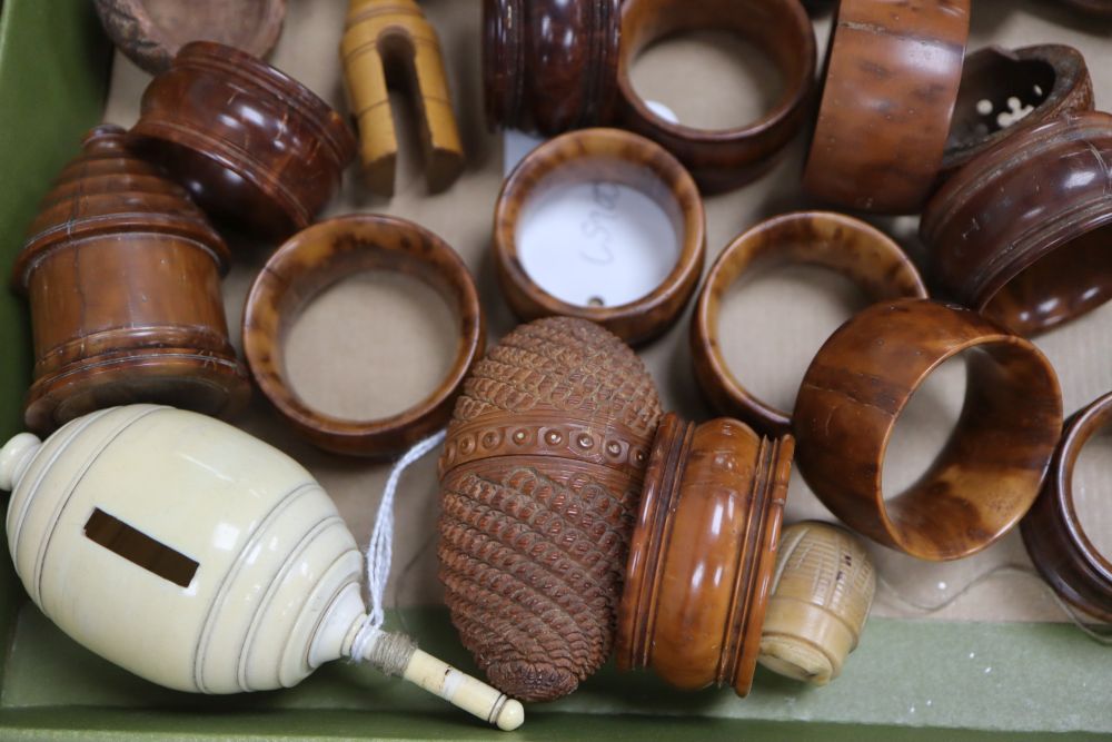 A 19th century ivory humming top, a coquilla nut humming top and a group of coquilla nut carvings and napkin rings